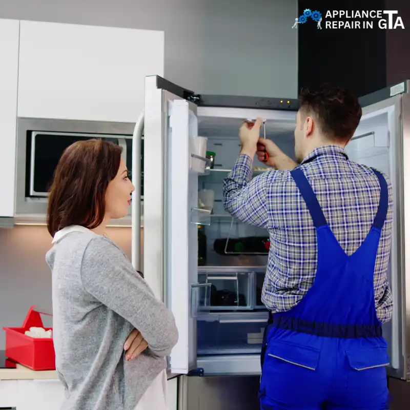 Technician repairing refrigerator door and cooling system in Toronto home.
