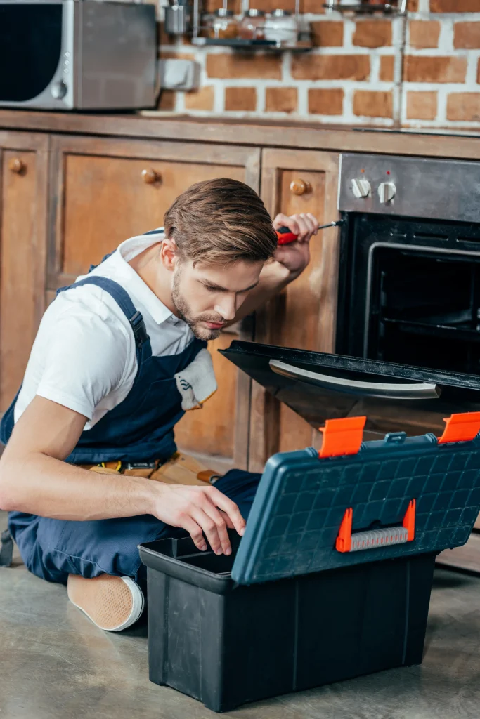 Appliance repair expert testing stove wiring and temperature control.