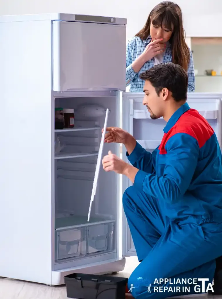 Fridge repair technician in Brampton inspecting refrigerator issues for a homeowner.